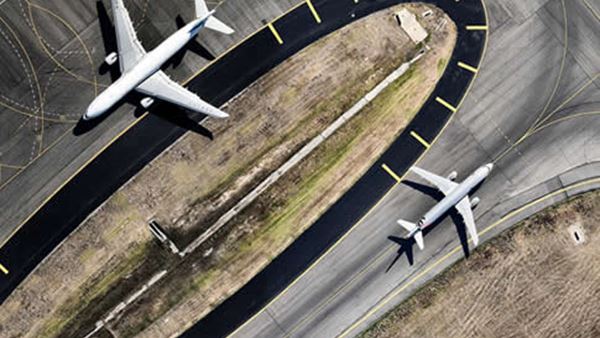 Two planes taxiing on a runway